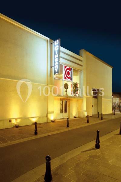 Façade éclairée d'un bâtiment moderne avec une enseigne lumineuse ’Le Cinéart’ et une entrée vitrée.