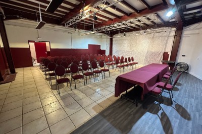 Miniature Location salle Nanterre (Hauts-de-Seine) - Le Cinéart #6 Table décorée pour un mariage avec chaises blanches, nappe bleue, fleurs blanches et éléments dorés sur une estrade.