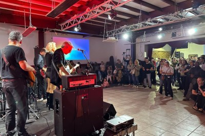 Miniature Location salle Nanterre (Hauts-de-Seine) - Le Cinéart #7 Table décorée pour un mariage avec chaises blanches, nappe bleue, fleurs blanches et éléments dorés sur une estrade.
