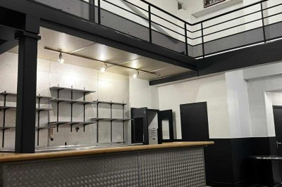 Table décorée pour un mariage avec chaises blanches, nappe bleue, fleurs blanches et éléments dorés sur une estrade.