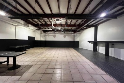 Table décorée pour un mariage avec chaises blanches, nappe bleue, fleurs blanches et éléments dorés sur une estrade.