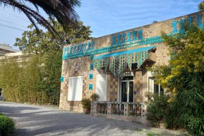 Salle lumineuse avec une grande table dressée pour un repas, décorée de fleurs blanches et rouges, entourée de chaises…