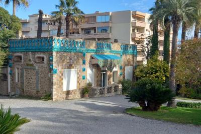 Salle lumineuse avec une grande table dressée pour un repas, décorée de fleurs blanches et rouges, entourée de chaises…