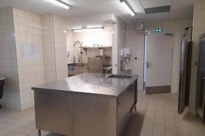 Miniature Cuisine Accueil lumineux avec comptoir blanc, porte vitrée à gauche laissant entrer la lumière et plante verte à droite.