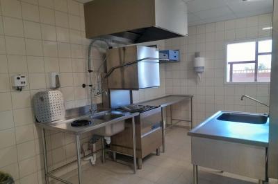 Miniature Office traiteur Accueil lumineux avec comptoir blanc, porte vitrée à gauche laissant entrer la lumière et plante verte à droite.