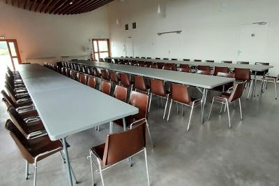 Miniature Salle Cristal Accueil lumineux avec comptoir blanc, porte vitrée à gauche laissant entrer la lumière et plante verte à droite.
