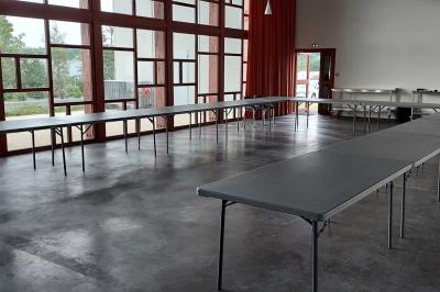 Miniature Salle Cristal Accueil avec comptoir blanc, porte-manteaux en arrière-plan, grande baie vitrée et plante verte à droite.