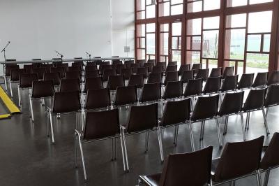 Miniature Salle Cristal Accueil avec comptoir blanc, porte-manteaux en arrière-plan, grande baie vitrée et plante verte à droite.