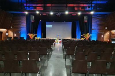 Miniature Salle Ebène Accueil avec comptoir blanc, porte-manteaux en arrière-plan, grande baie vitrée et plante verte à droite.