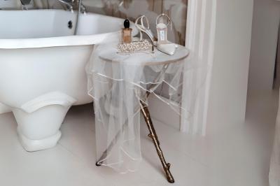 Table en bois longue dressée en extérieur, ornée de fleurs, citrons et vaisselle, entourée d'arbres et de verdure.