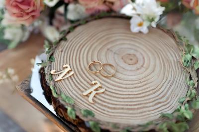 Table en bois longue dressée en extérieur, ornée de fleurs, citrons et vaisselle, entourée d'arbres et de verdure.