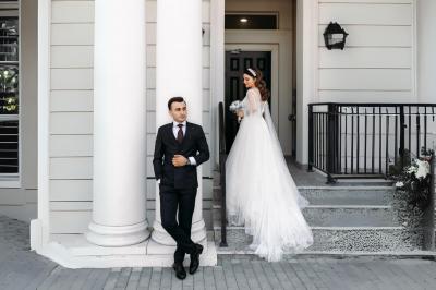 Table en bois longue dressée en extérieur, ornée de fleurs, citrons et vaisselle, entourée d'arbres et de verdure.
