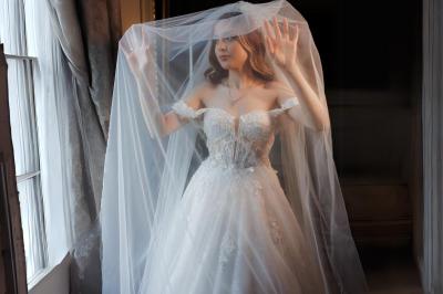 Table en bois longue dressée en extérieur, ornée de fleurs, citrons et vaisselle, entourée d'arbres et de verdure.