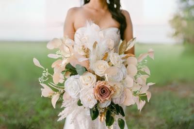 Table en bois longue dressée en extérieur, ornée de fleurs, citrons et vaisselle, entourée d'arbres et de verdure.