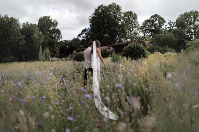 Table en bois longue dressée en extérieur, ornée de fleurs, citrons et vaisselle, entourée d'arbres et de verdure.