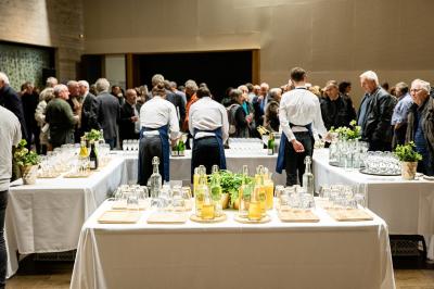 Miniature Troyes la Champagne Events #7 Femme de dos dans une chambre mansardée avec poutres apparentes, lit, télévision et baignoire en arrière-plan.