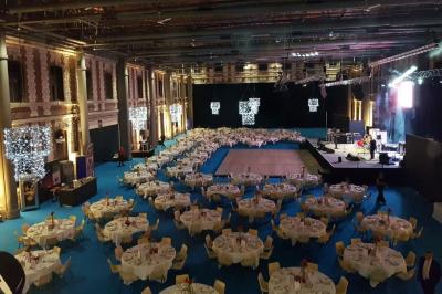 Miniature Troyes la Champagne Events #10 Femme de dos dans une chambre mansardée avec poutres apparentes, lit, télévision et baignoire en arrière-plan.