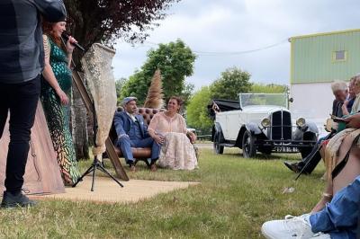 Miniature Cérémonie laïque à l'Hippodrome de Maure de Bretagne Seau à champagne avec bouteille et quatre flûtes vides sur une table, vue sur un paysage extérieur avec pelouse.