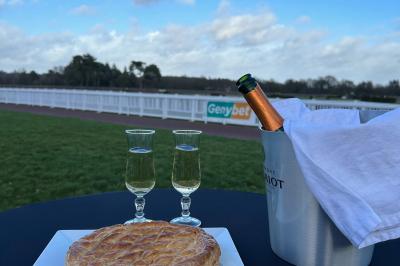 Miniature Dégustez votre champagne au millieu du rond de présentation face à la piste de l'Hippodrome Seau à champagne avec bouteille et quatre flûtes vides sur une table, vue sur un paysage extérieur avec pelouse.
