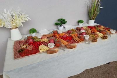 Un motocycliste effectue un saut spectaculaire au-dessus de véhicules dans un espace extérieur ensoleillé.