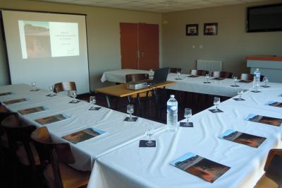 Un motocycliste effectue un saut spectaculaire au-dessus de véhicules dans un espace extérieur ensoleillé.