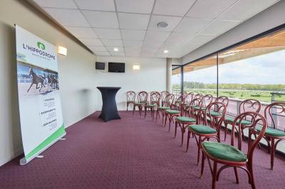 Un motocycliste effectue un saut spectaculaire au-dessus de véhicules dans un espace extérieur ensoleillé.