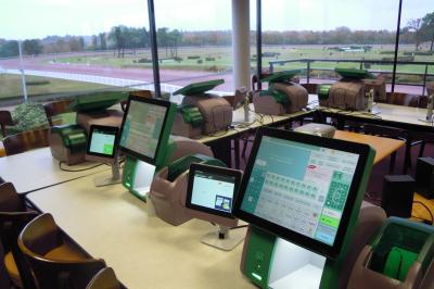 Un motocycliste effectue un saut spectaculaire au-dessus de véhicules dans un espace extérieur ensoleillé.