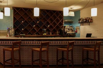 Plateau en bois garni de charcuteries, fromages, cornichons et salade, posé sur une table en bois.