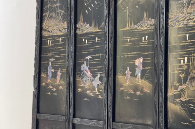 Façade d'une grande maison en pierre claire avec volets bleus, entourée d'un jardin et d'une allée gravillonnée.