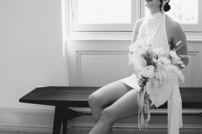 Façade d'une grande maison en pierre claire avec volets bleus, entourée d'un jardin et d'une allée gravillonnée.