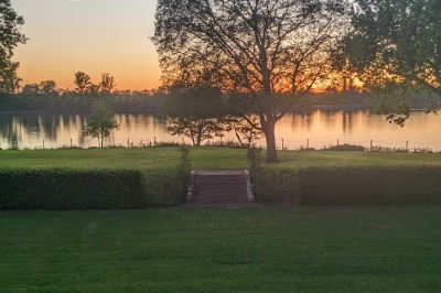 Miniature Location salle Arveyres (Gironde) - Château Larteau #52 Vue d'un jardin verdoyant avec un arbre central, un escalier en pierre et un lac au coucher du soleil.