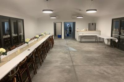 Parking extérieur de nuit avec plusieurs voitures alignées, éclairé par des lumières provenant d'un bâtiment au fond.