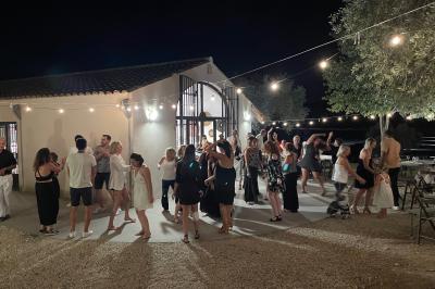 Parking extérieur de nuit avec plusieurs voitures alignées, éclairé par des lumières provenant d'un bâtiment au fond.