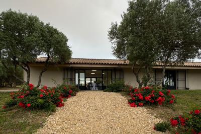 Parking extérieur de nuit avec plusieurs voitures alignées, éclairé par des lumières provenant d'un bâtiment au fond.