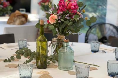Arbuste de rhododendrons roses en fleurs dans un jardin verdoyant, sous un ciel bleu ensoleillé.