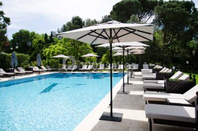 Salle de réunion lumineuse avec des tables disposées en U, des chaises noires et des fenêtres donnant sur un espace vert.