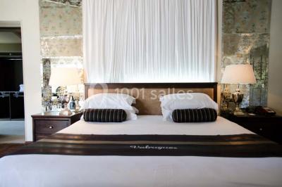 Salle de réunion lumineuse avec des tables disposées en U, des chaises noires et des fenêtres donnant sur un espace vert.