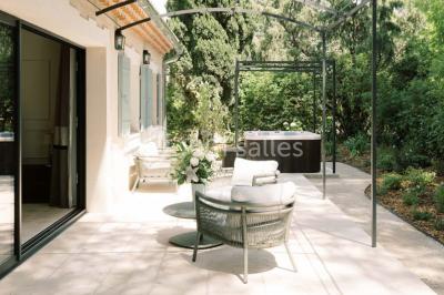 Salle de réunion lumineuse avec des tables disposées en U, des chaises noires et des fenêtres donnant sur un espace vert.