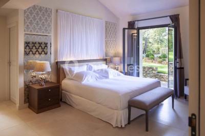 Salle de réunion lumineuse avec des tables disposées en U, des chaises noires et des fenêtres donnant sur un espace vert.