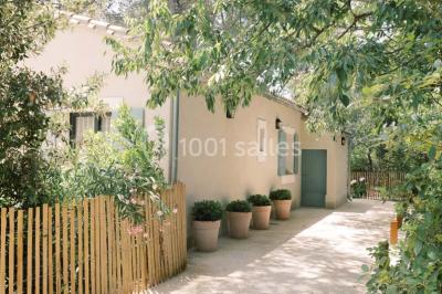 Salle de réunion lumineuse avec des tables disposées en U, des chaises noires et des fenêtres donnant sur un espace vert.
