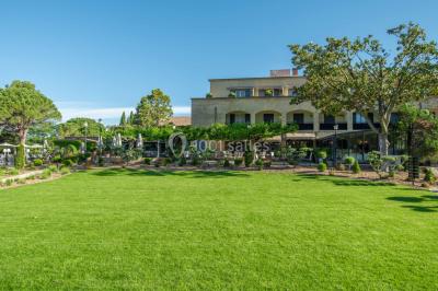 Salle de réunion lumineuse avec des tables disposées en U, des chaises noires et des fenêtres donnant sur un espace vert.
