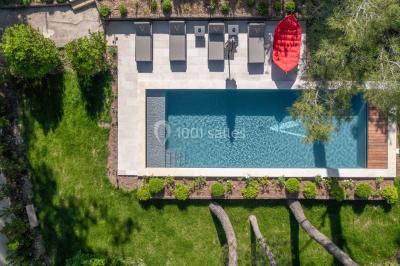 Salle de réunion lumineuse avec des tables disposées en U, des chaises noires et des fenêtres donnant sur un espace vert.