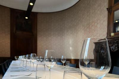 Couloir lumineux avec moquette verte, plantes en pot et portes blanches vitrées au fond.