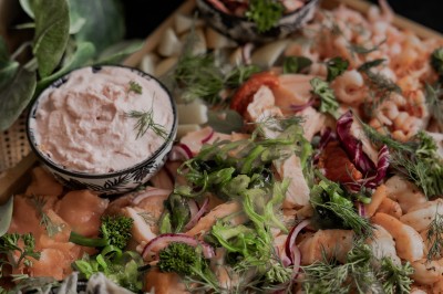 Assortiment de sauces variées dans des bols avec étiquettes, disposées sur une table sombre.