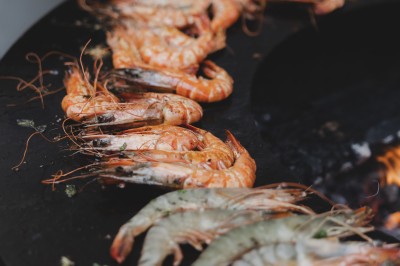 Assortiment de sauces variées dans des bols avec étiquettes, disposées sur une table sombre.