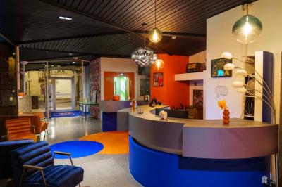 Mur décoré de vinyles, panneau des Rolling Stones et lampes modernes, avec un papier peint coloré en arrière-plan.