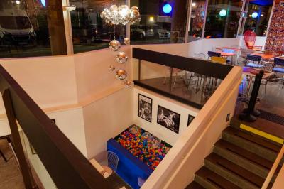 Mur décoré de vinyles, panneau des Rolling Stones et lampes modernes, avec un papier peint coloré en arrière-plan.