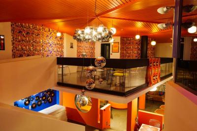 Mur décoré de vinyles, panneau des Rolling Stones et lampes modernes, avec un papier peint coloré en arrière-plan.