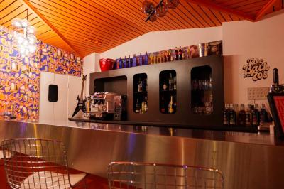 Mur décoré de vinyles, panneau des Rolling Stones et lampes modernes, avec un papier peint coloré en arrière-plan.