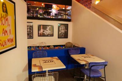 Mur décoré de vinyles, panneau des Rolling Stones et lampes modernes, avec un papier peint coloré en arrière-plan.